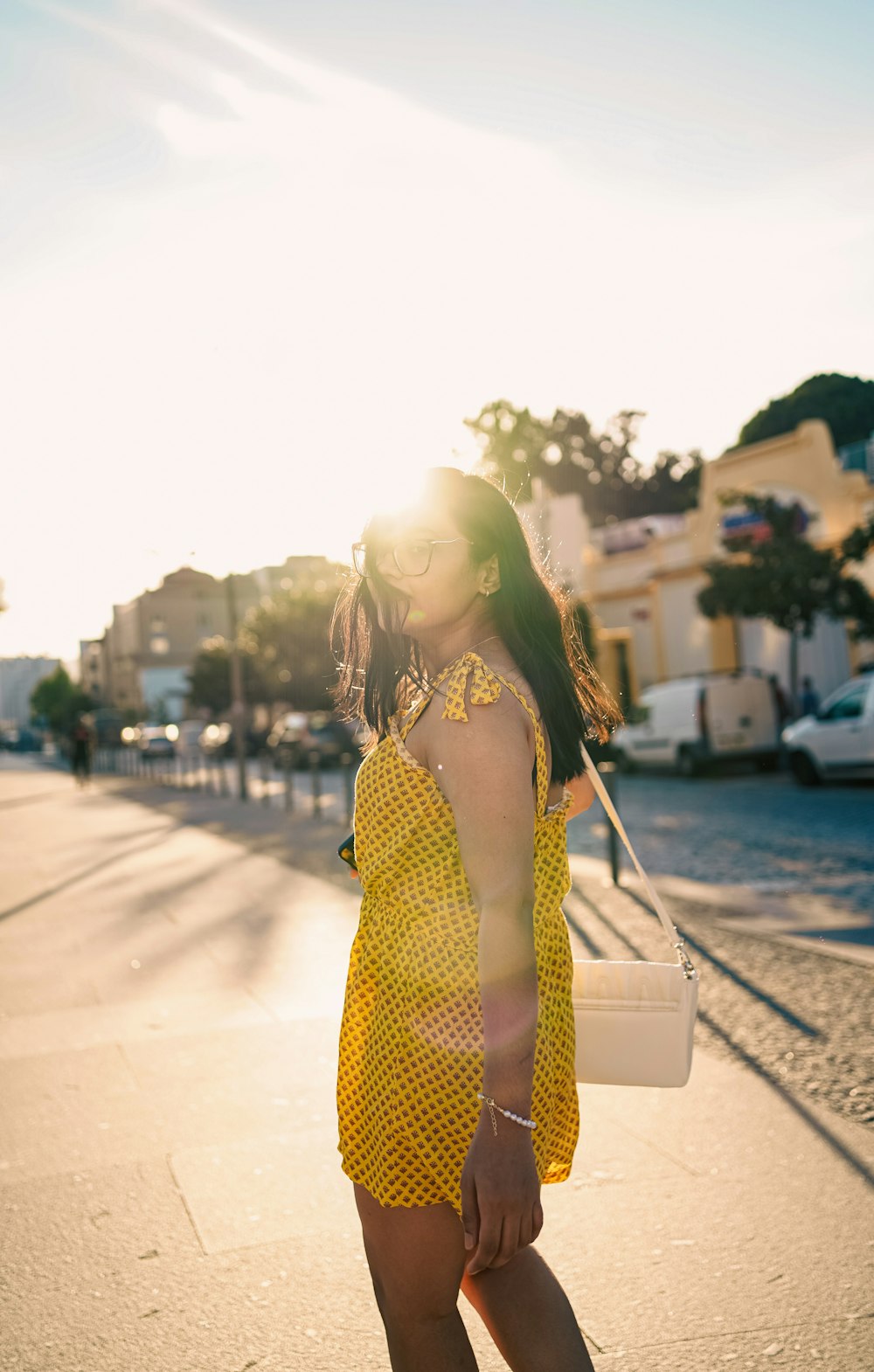 a woman in a yellow dress is walking down the street