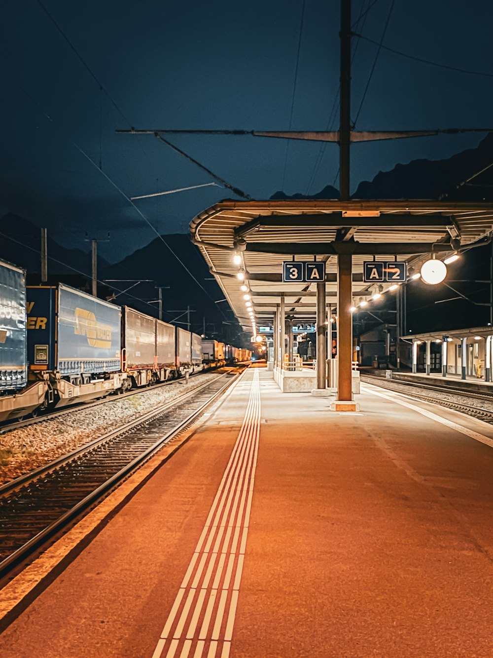 a train pulling into a train station at night