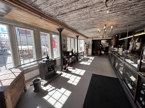 Interior shot showing restored hardwood floors and vintage fixtures.