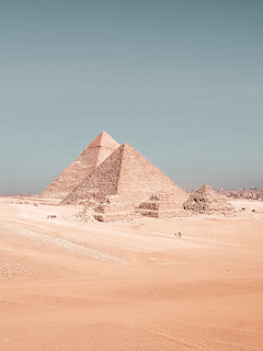 The majestic pyramids of Giza standing tall under a clear blue sky.