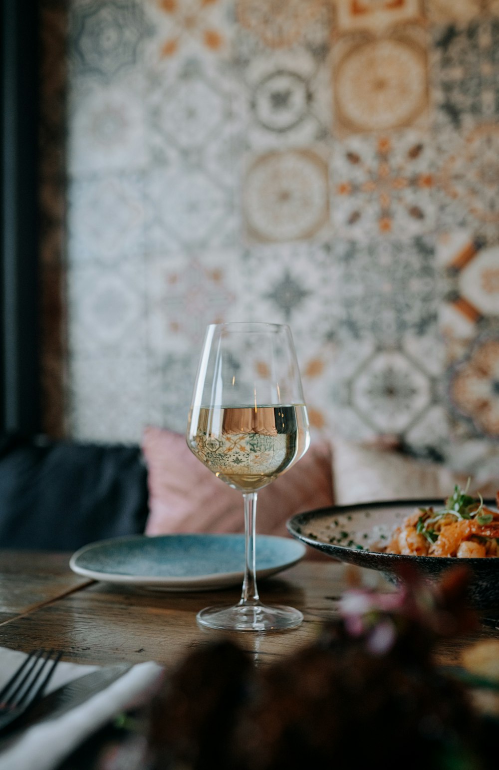 a glass of wine sitting on top of a wooden table