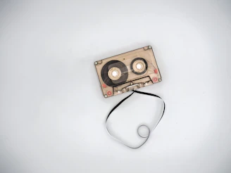 A vintage cassette tape lying on a colorful graffiti background with a subtle 3D glow effect.