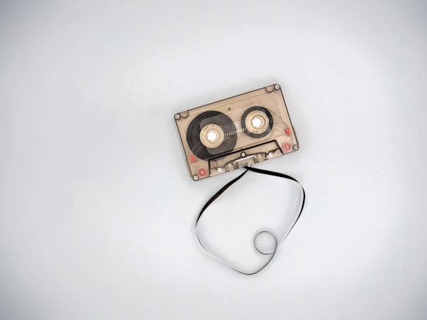 A vintage cassette tape lying on a colorful graffiti background with a subtle 3D glow effect.