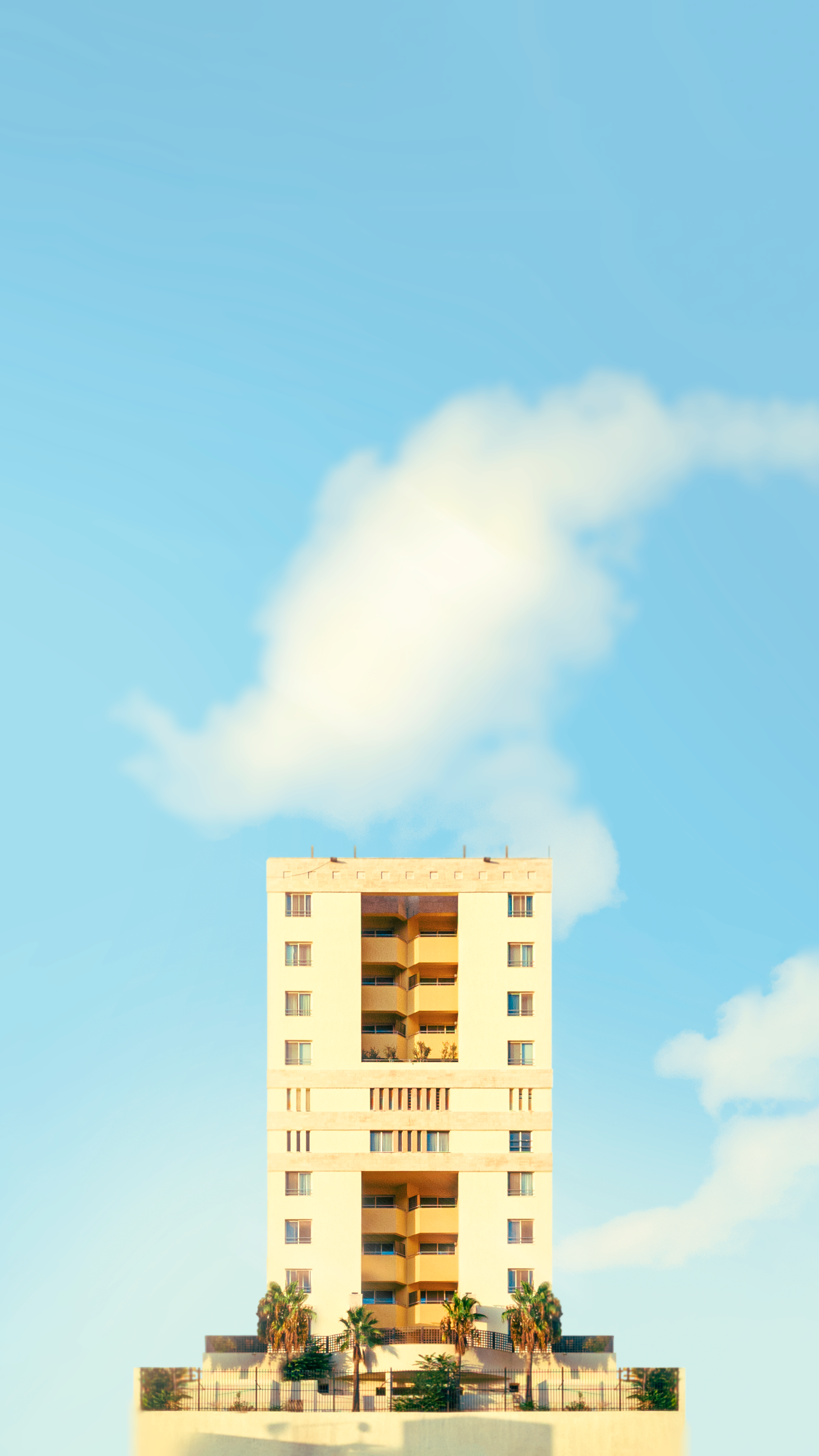 a tall white building sitting on top of a lush green field