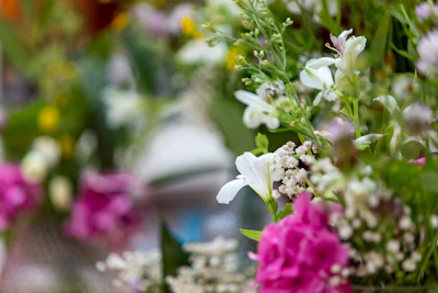 A close-up of an elegant bridal bouquet with soft pink and white artificial flowers, arranged delicately with greenery.
