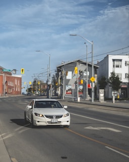 An instructor giving driving lessons in a calm urban environment with clear road signs.