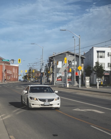 An instructor giving driving lessons in a calm urban environment with clear road signs.