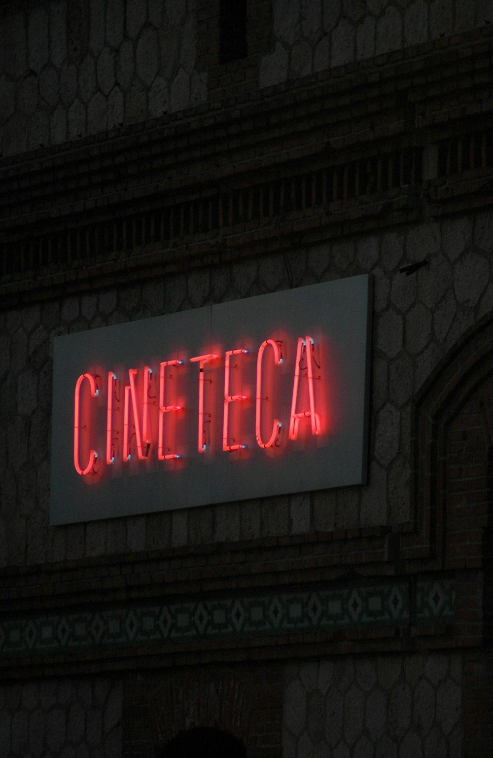 a red neon sign on a brick building