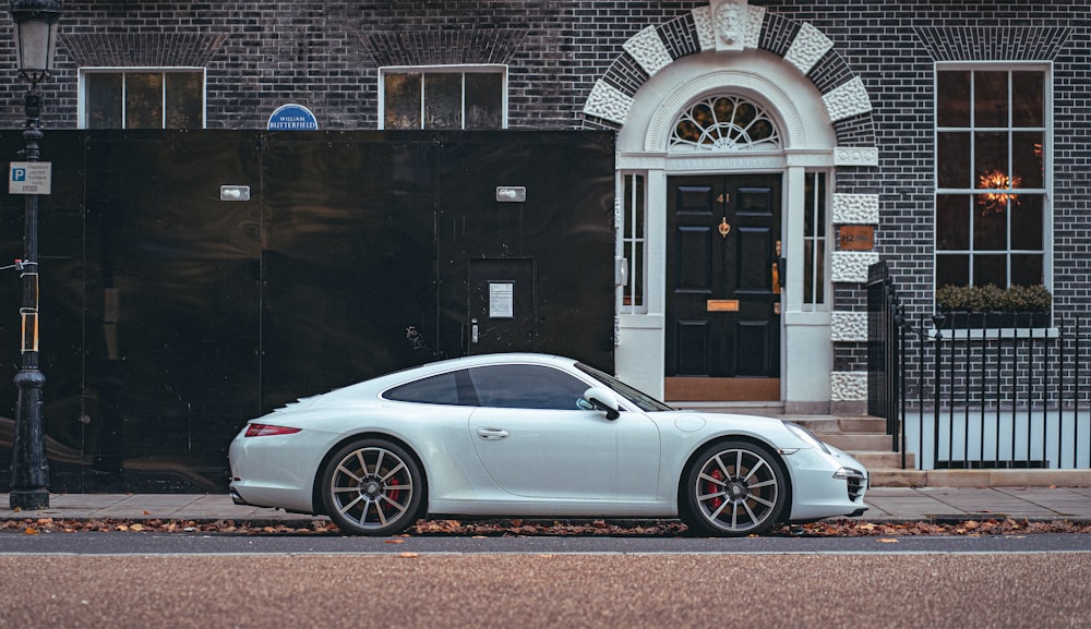 a white sports car parked in front of a building