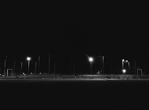 Nighttime sports event illuminated by stadium lights with creators capturing moments.