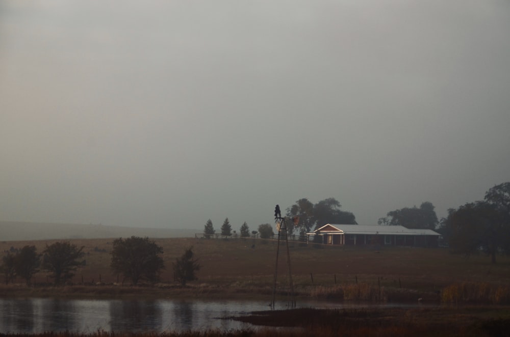 a house in a field with a lake in the foreground