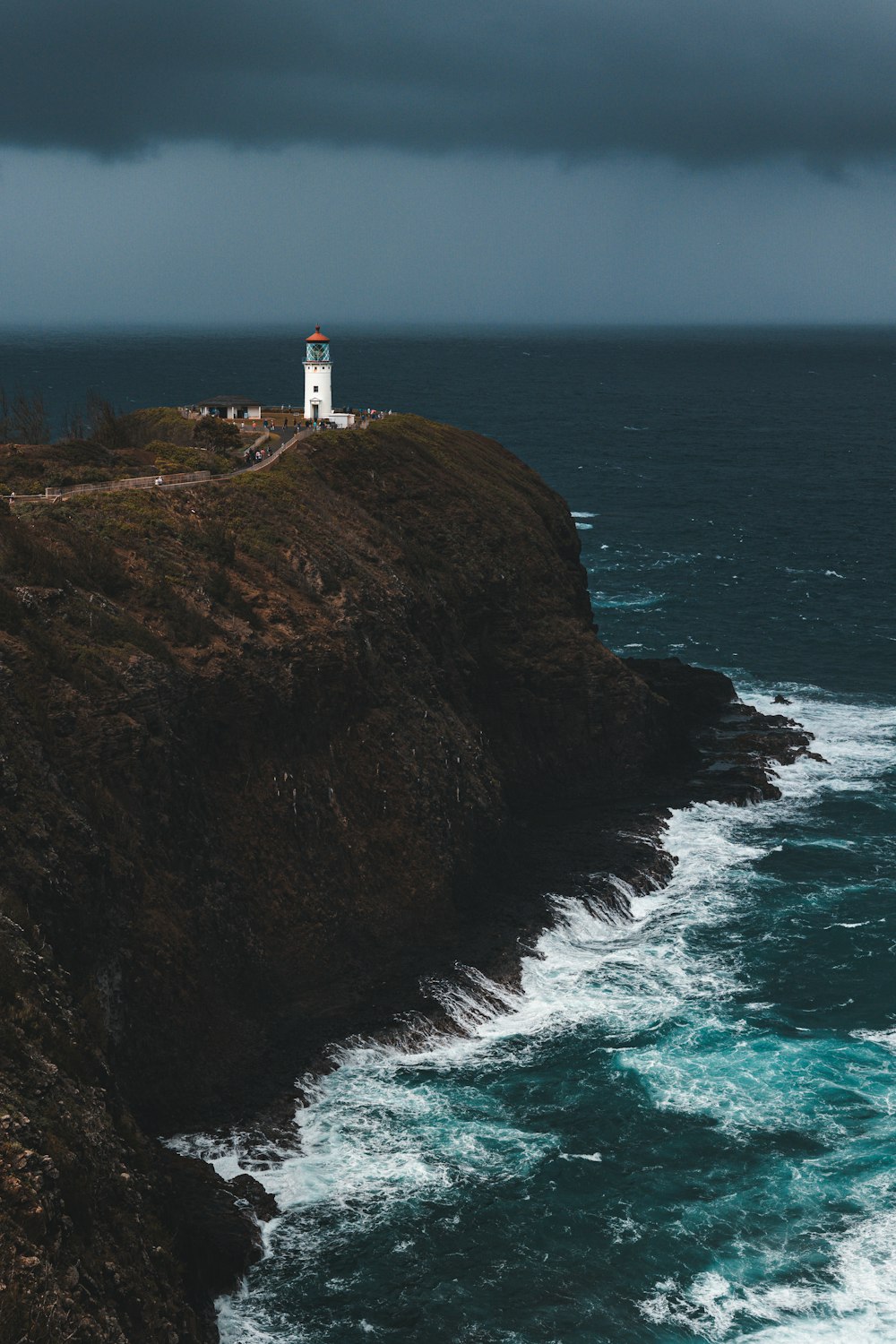 a lighthouse on top of a cliff near the ocean