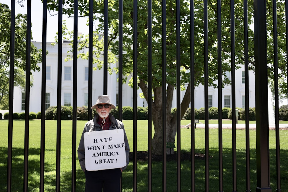 Um homem segurando um cartaz que diz que o ódio não fará a América grande