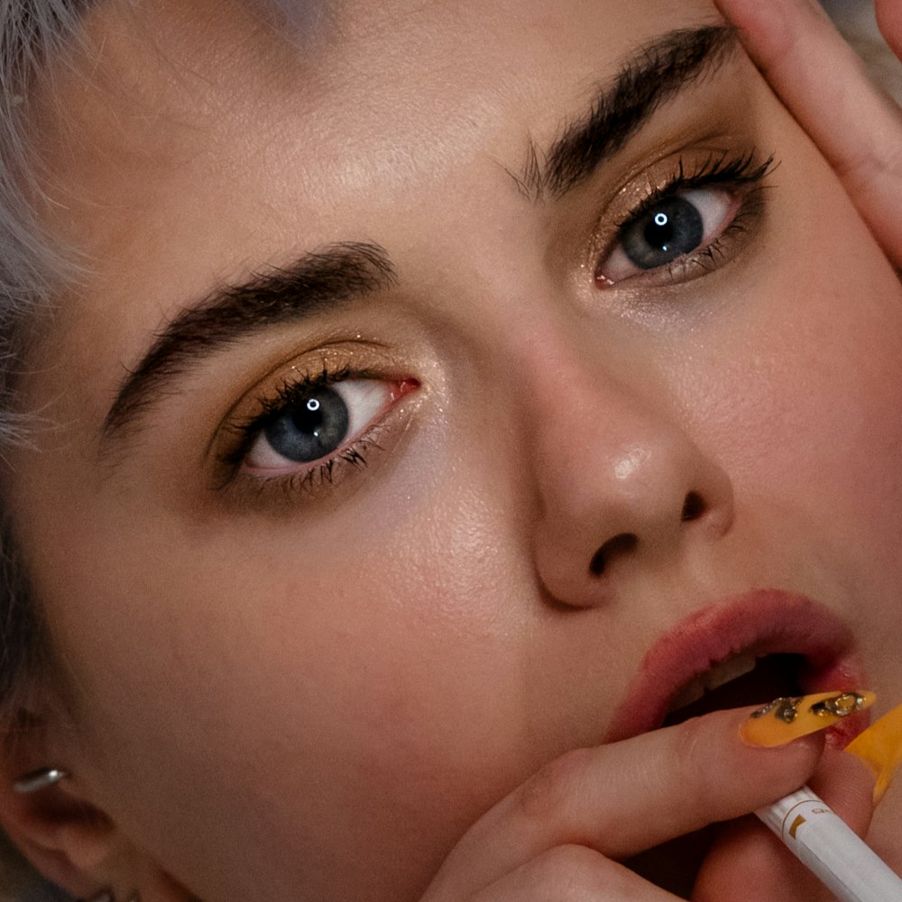 a close up of a person holding a cigarette