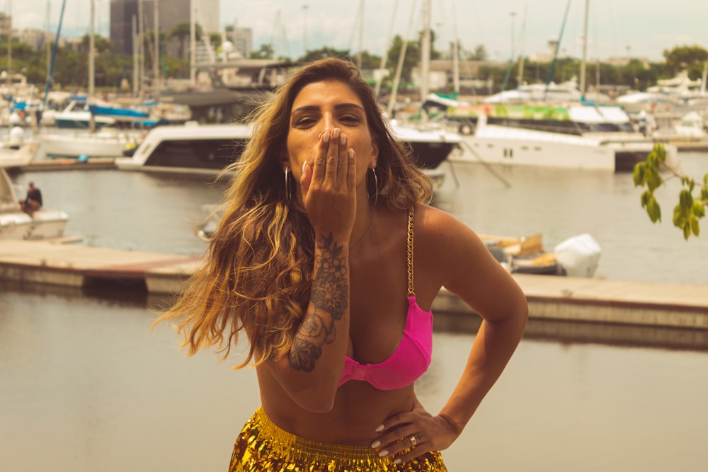 a woman in a bikini standing in front of a marina