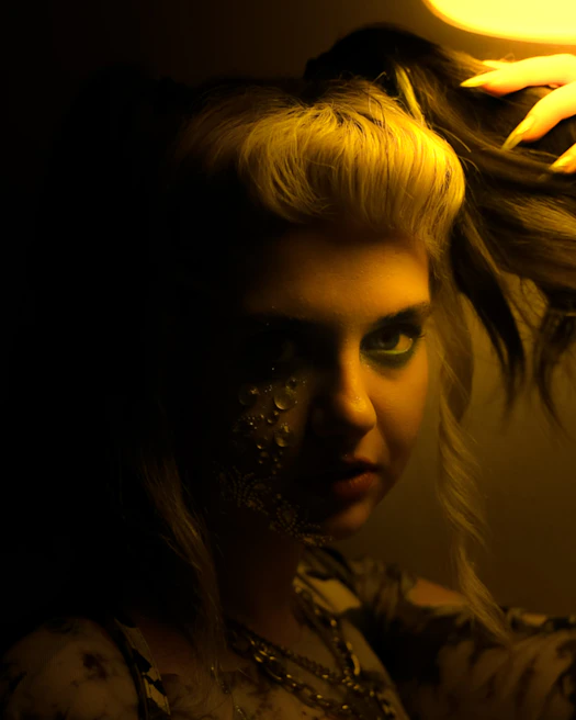 Close-up of intricate costume details with bold textures and theatrical makeup under moody lighting.
