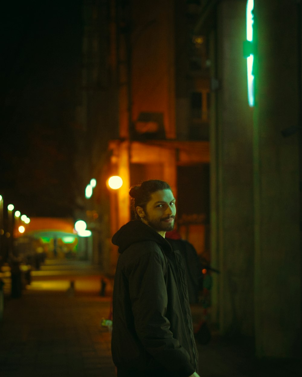a man standing on a sidewalk at night