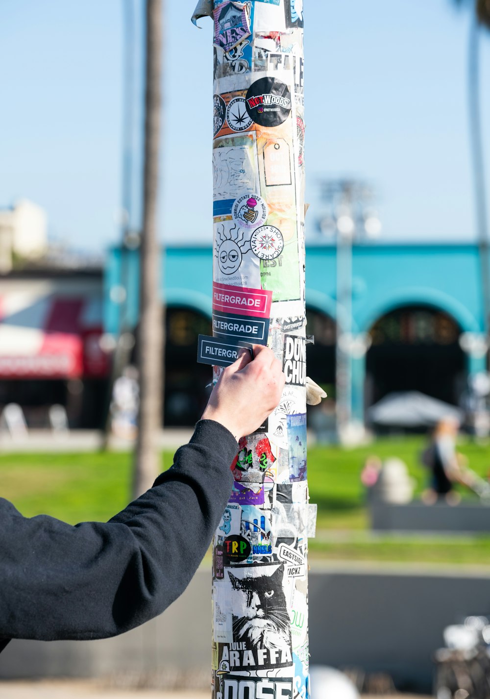 a person is putting stickers on a pole