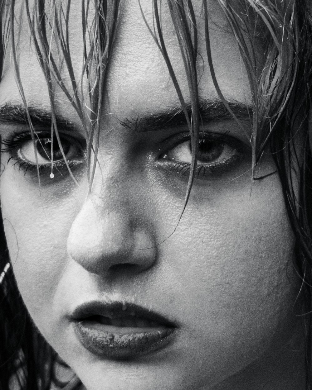 a black and white photo of a woman with wet hair