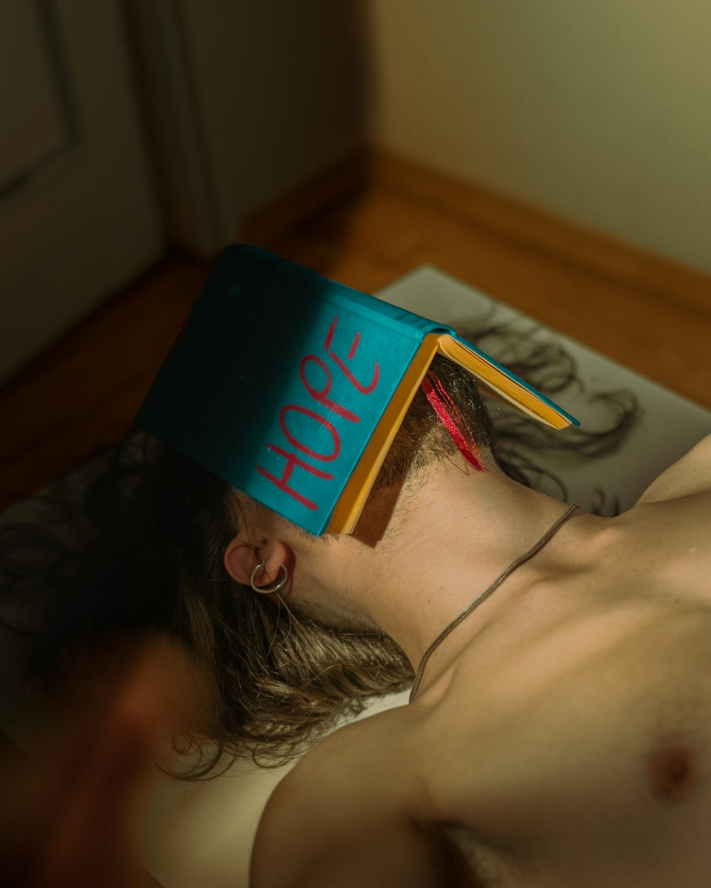 a shirtless man with a book on his head