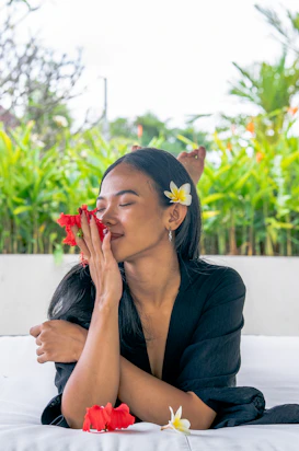a woman laying on a bed with flowers in her hair