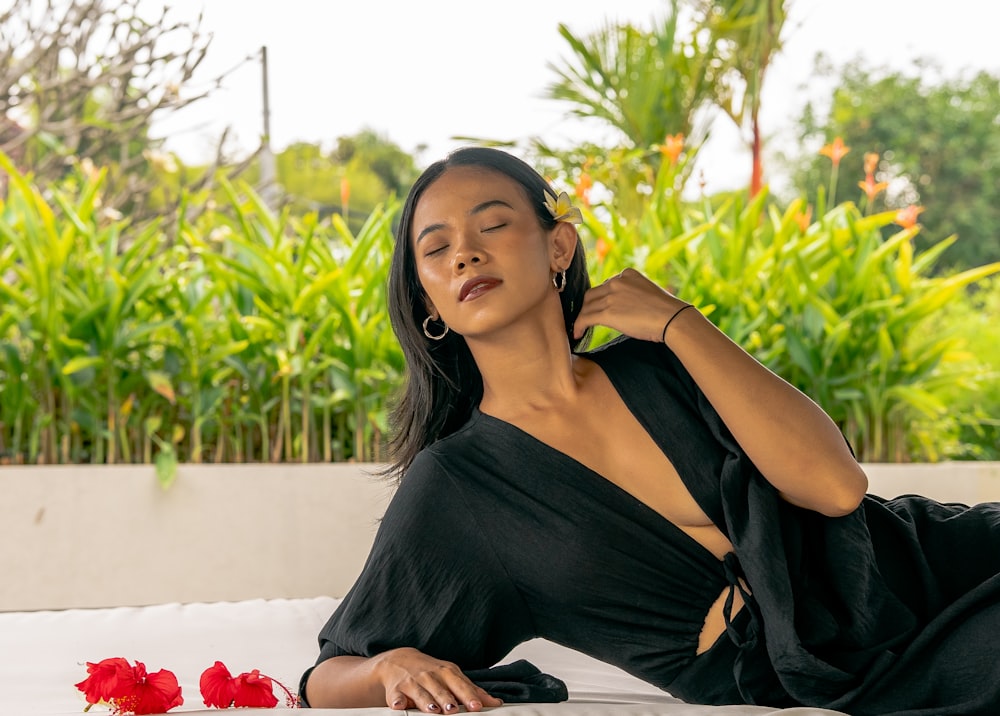 a woman in a black dress laying on a white couch