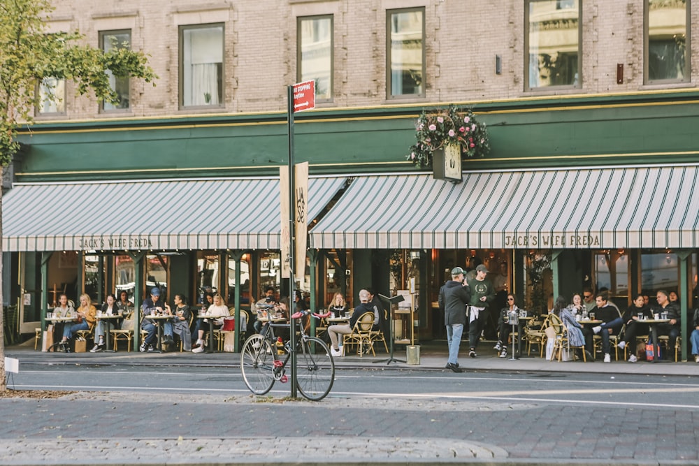 a group of people sitting at tables outside of a restaurant