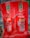 Two fire extinguishers are positioned on a red stand, one labeled as CO2 and the other as Foam. Both extinguishers have instructional labels with icons and text, indicating their uses and safety precautions.