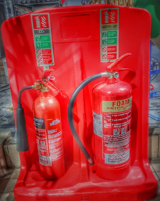 A variety of fire extinguishers displayed on a shelf.