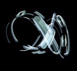 abstract light trails weaving around a performer in a minimalist black space