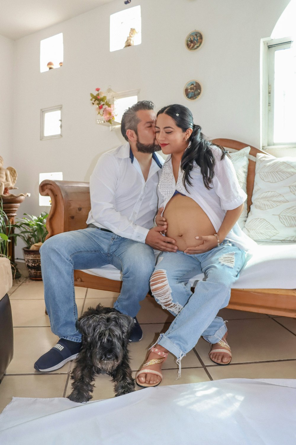 a man and woman sitting on a couch with a dog