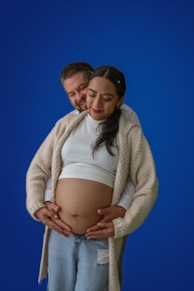 a pregnant woman is holding her husband's belly