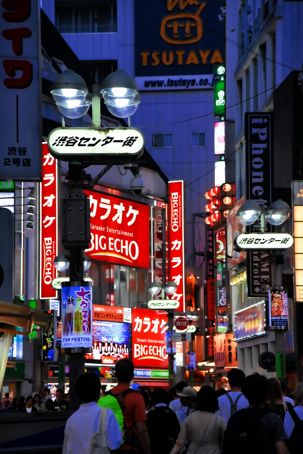 a group of people walking down a street at night