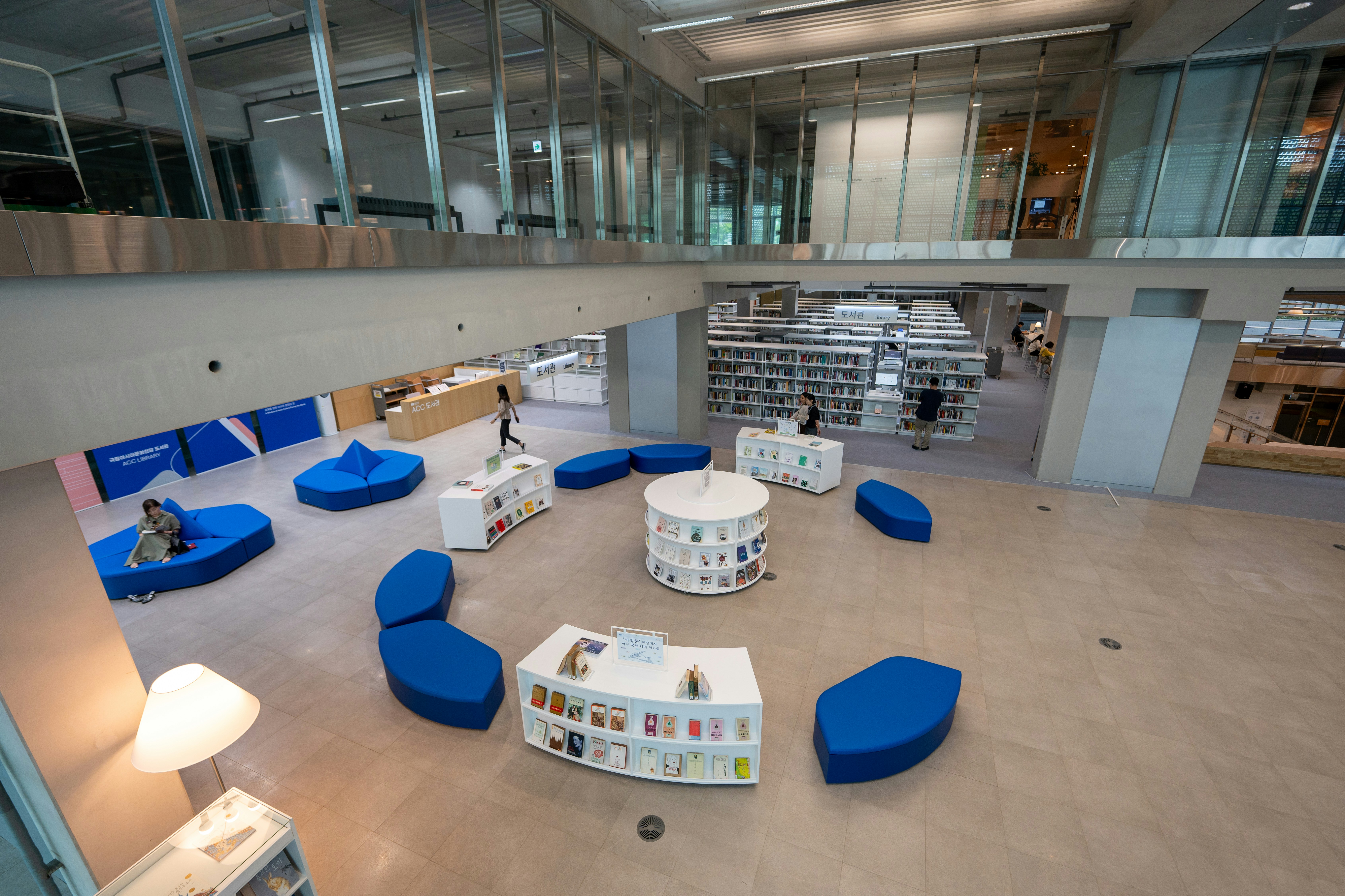 Colorful books stacked on bright white shelves, airy library setting