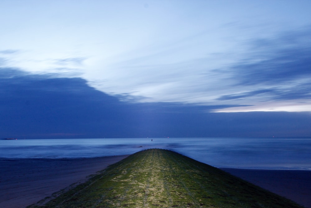 a bench sitting on top of a grass covered beach