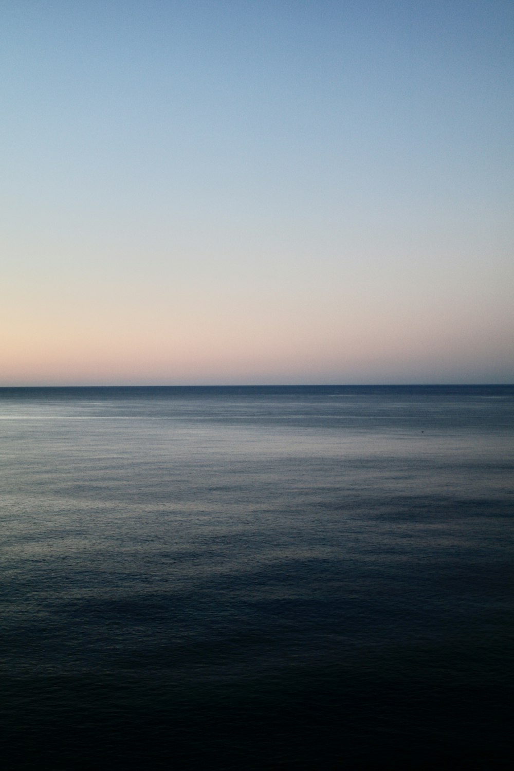 a large body of water sitting under a blue sky