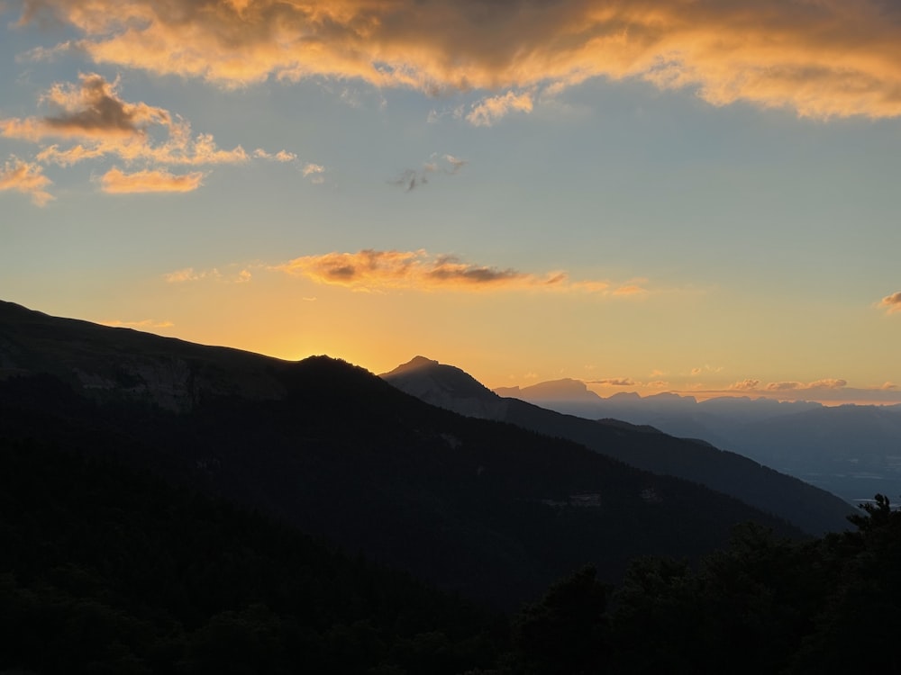 the sun is setting over a mountain range