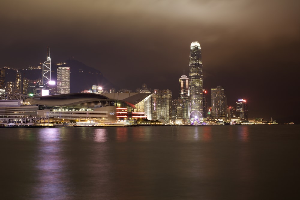 a city skyline at night with lights reflecting off the water