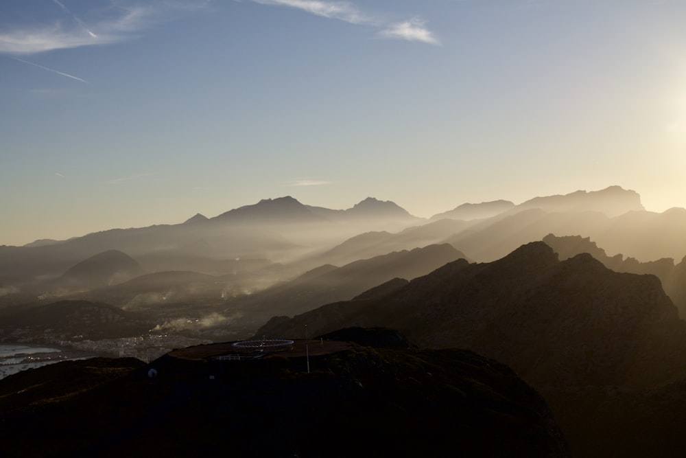 the sun is shining over a mountain range