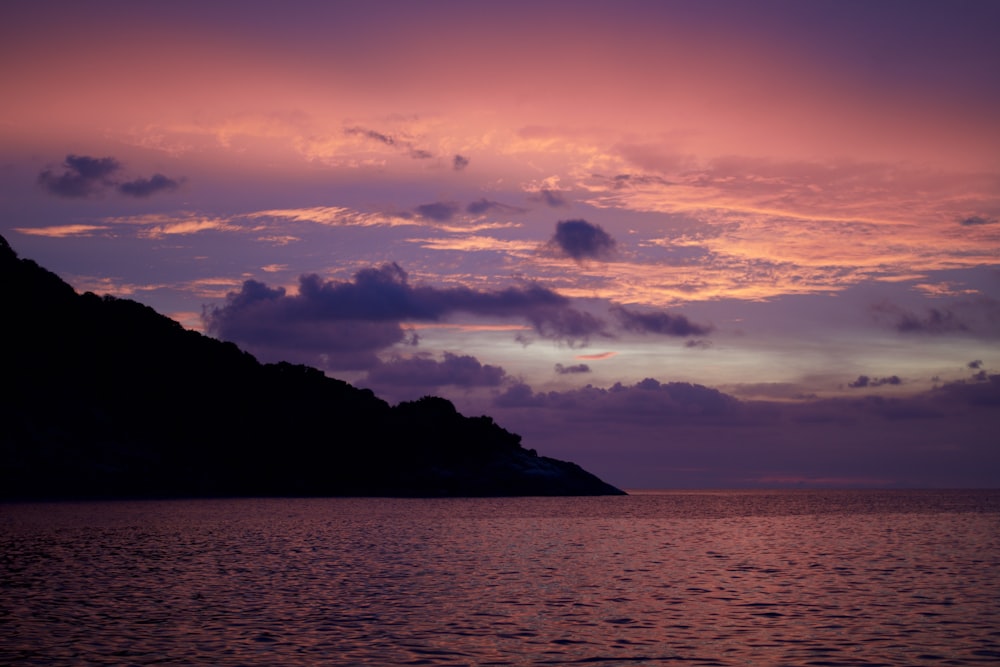 a large body of water with a hill in the background