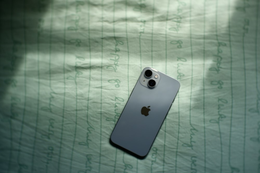 an iphone is laying on a sheet on a bed