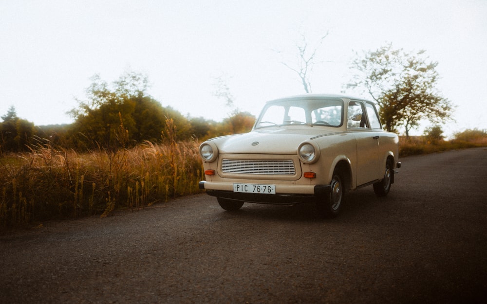 an old car is parked on the side of the road