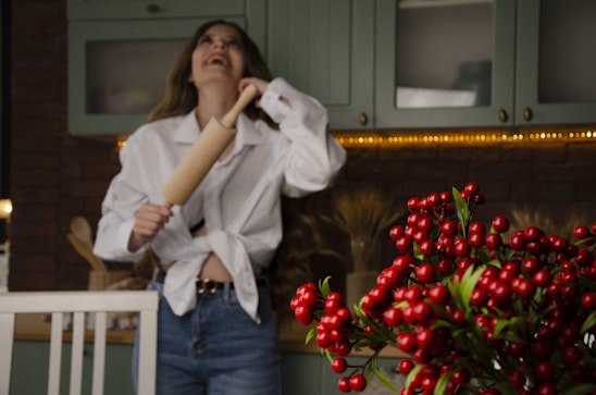 A woman joyfully baking in a bright kitchen.