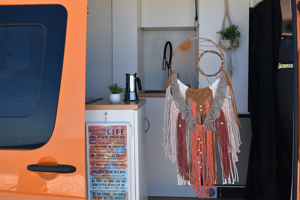 an orange truck with a dream catcher hanging from it's side