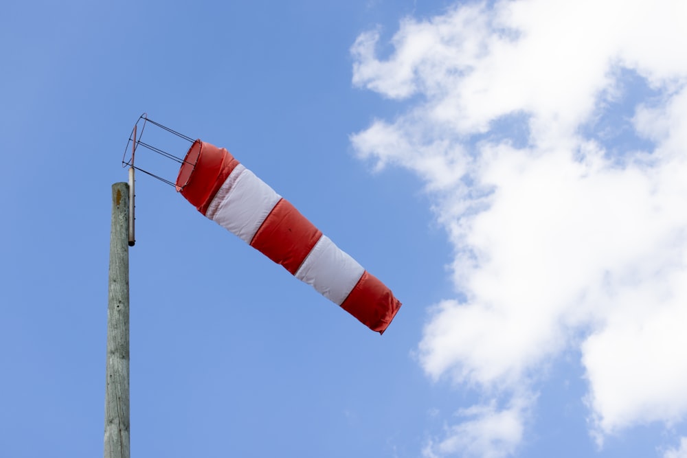 a red and white striped flag on a pole