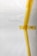 A white surface partially covered with strips of yellow masking tape arranged in an abstract pattern. There is a visible barcode on one piece of tape.