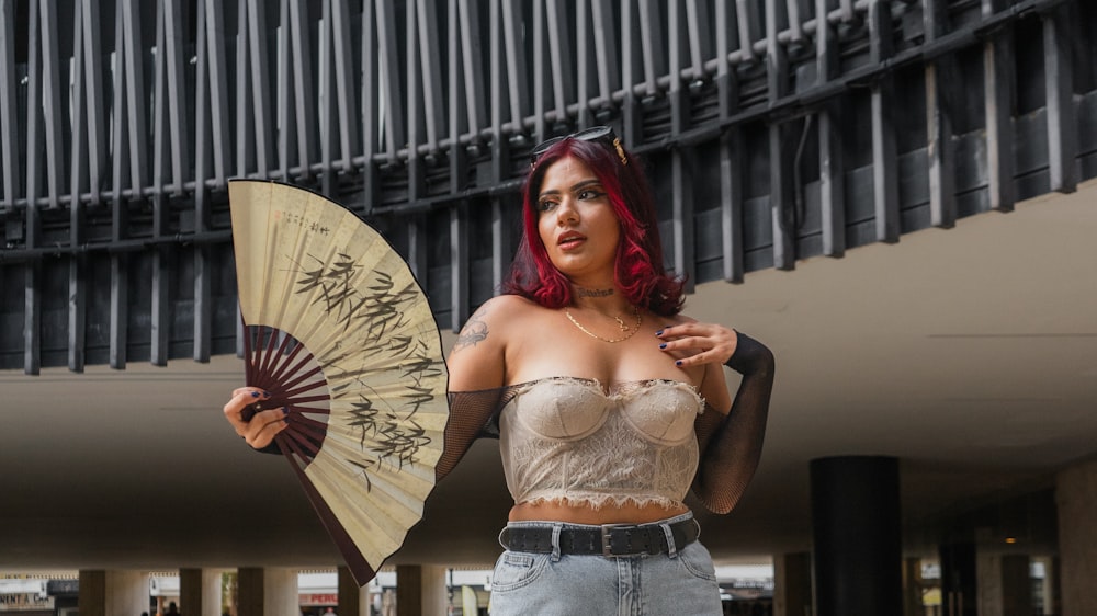 a woman with red hair is holding a fan