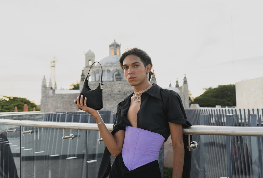 a man in a corset holding a pair of shoes