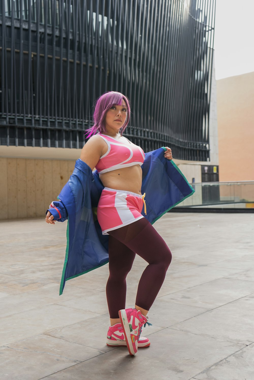 a woman in a pink and blue outfit is posing for a picture