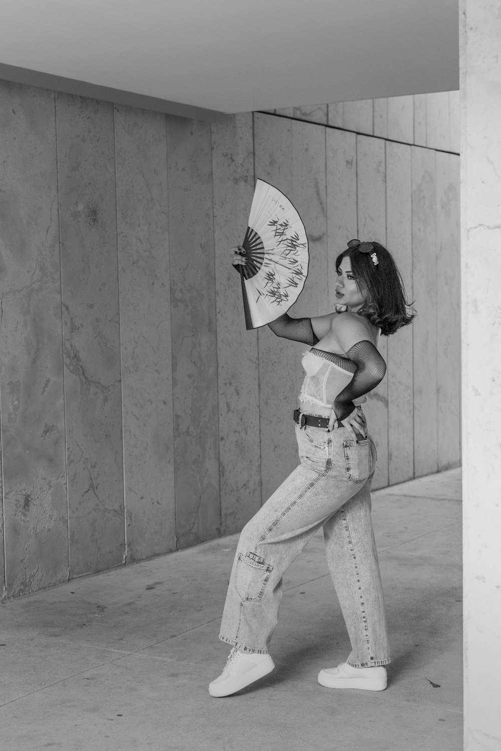 a woman is holding a fan and posing for a picture